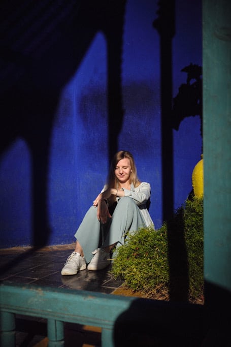 Portrait vor der blauen Wand des Ateliers im Jardin Majorelle in Marrakesch